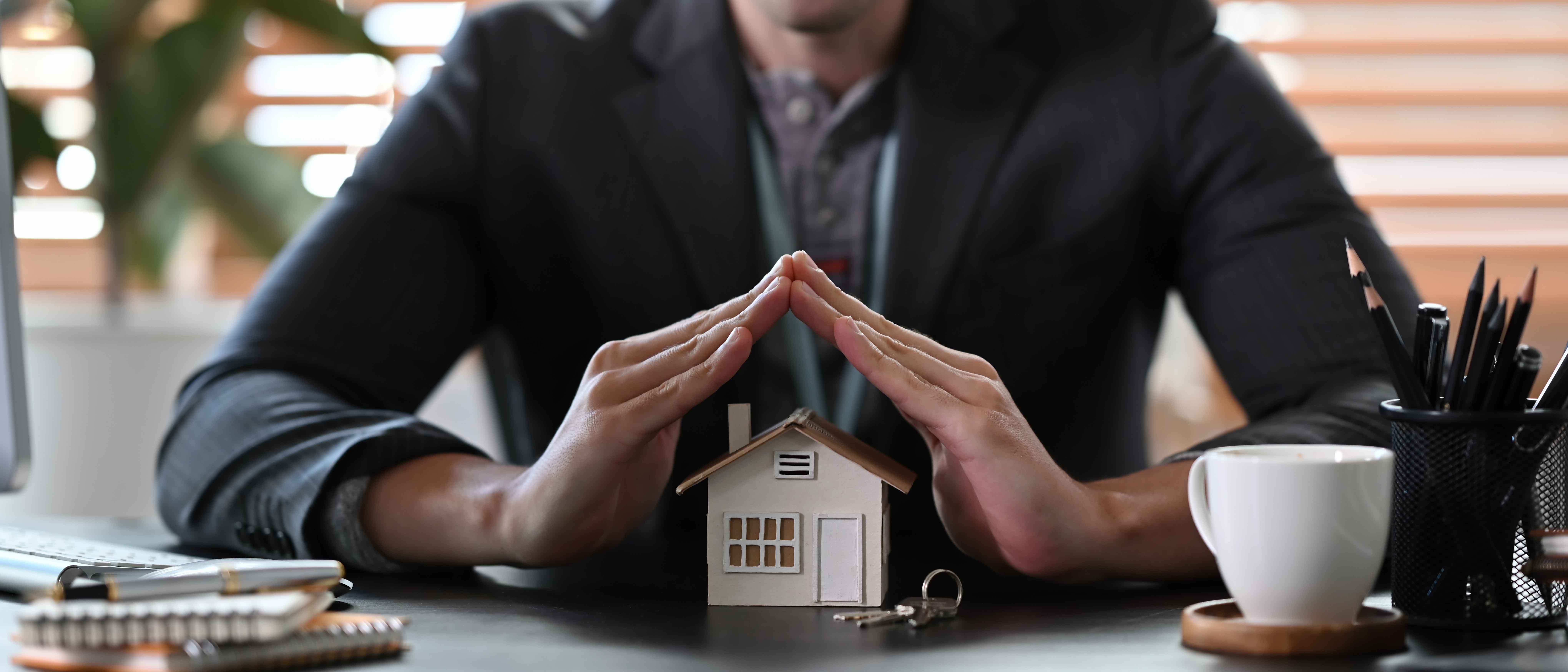 Man protective hand over house